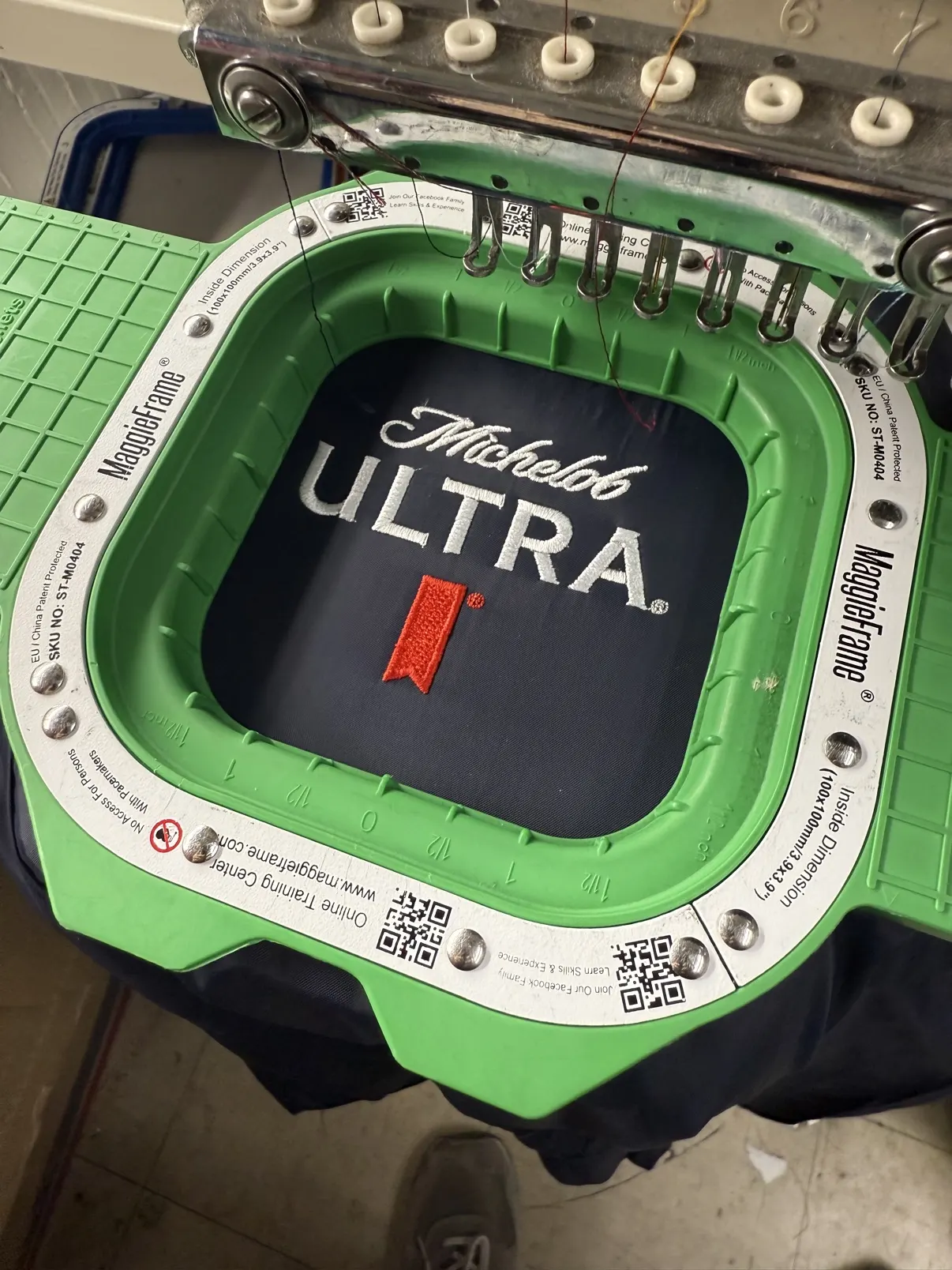 Michelob Ultra logo stitching out in an embroidery hoop